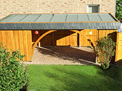 Carport 410x700 cm · Lärche · Holzdach mit Dachpappe & Schweißbahn · Schindelblende 2-reihig Echtschiefer · 2 Leimholzbögen · Längsseite geschlossen (Wandelemente)